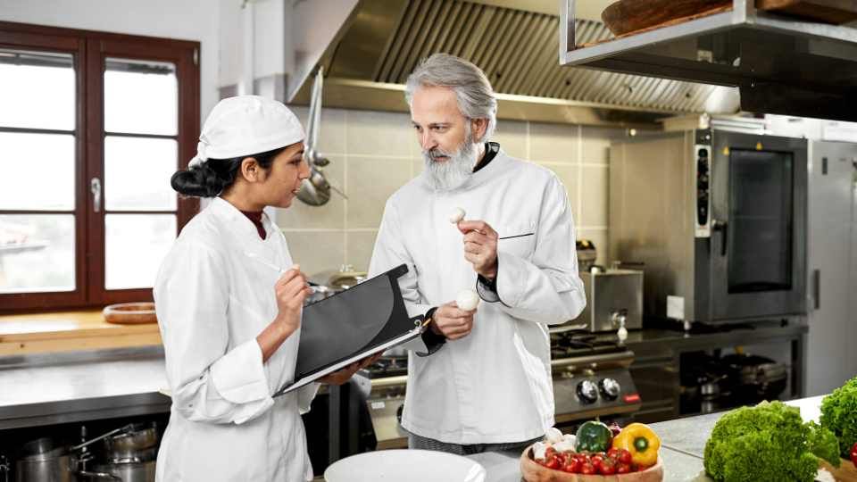 a sous chef talking to a cook